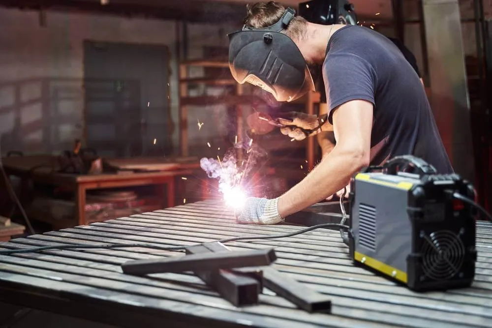 Workers are welding using welding machines.